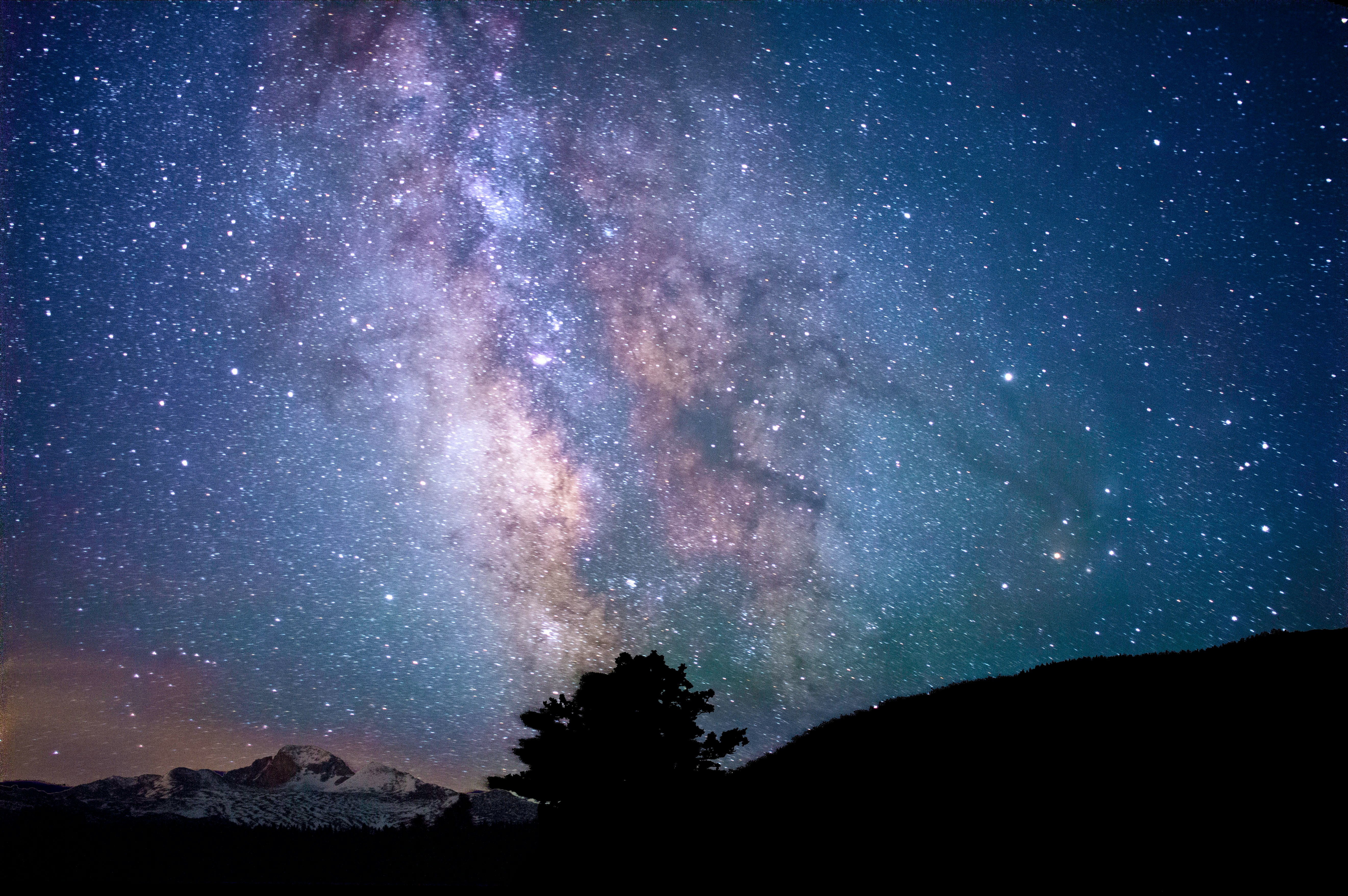 silhouette of trees and mountain under blue sky at nighttime